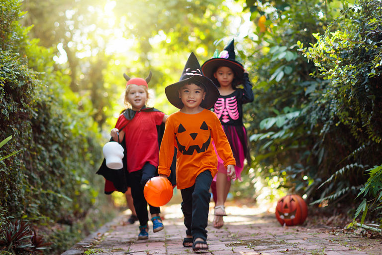 Kids Trick Or Treat On Halloween Night. Child At Decorated House
